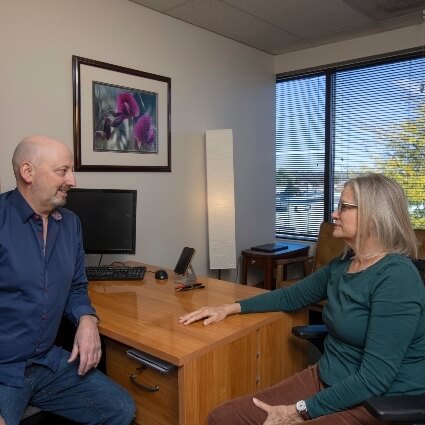 Dr. Munn listening attentively to a patient during a consultation.